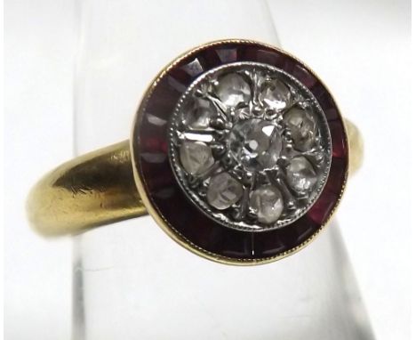 Yellow metal ring with central panel of small Diamonds with a red stone surround  