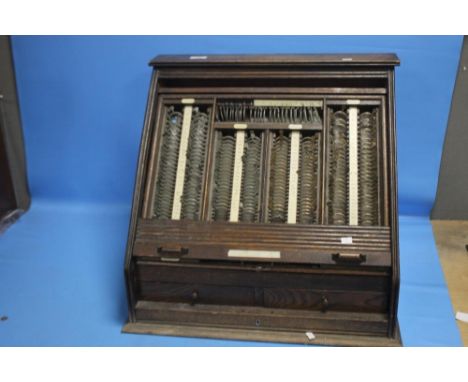 A VINTAGE OPTICIANS CABINET WITH ROLLER SHUTTER FRONT AND DRAWERS BELOW CONTAINING A QUANTITY OF LENSES AND RELATED EQUIPMENT