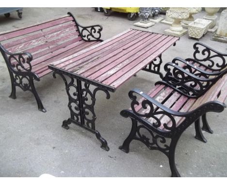 A CAST IRON AND WOODEN GARDEN SET COMPRISING A TABLE, TWO CHAIRS AND A BENCH