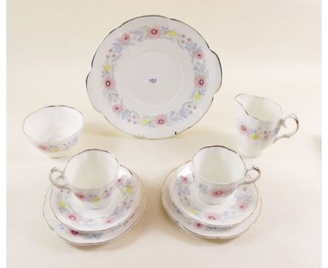 A Susie Cooper tea service painted flowers comprising: twelve cups (2 cups a/f) and saucers, twelve tea plates, two cake plat