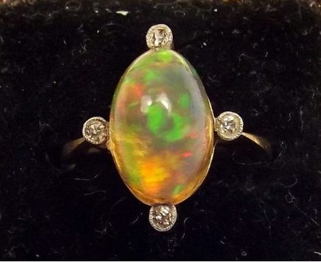 An 18ct gold oval cabochon cut opal ring set four diamonds 