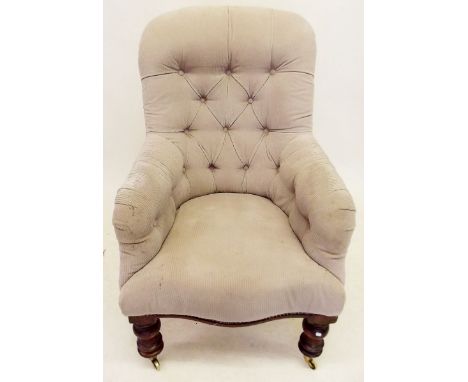 A Victorian button back armchair on turned supports 
