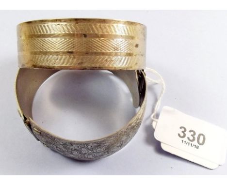 A silver bangle and a white metal one 