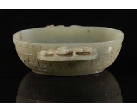 A CHINESE CELADON JADE OVAL BOWL with a chilong climbing along the projecting side handles, the body with archaistic decorati