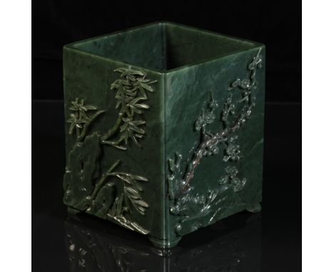 A CHINESE "SPINACH GREEN" JADE BRUSHPOT probably Qing, with a square body carved with panels of pine trees, flowering plants 