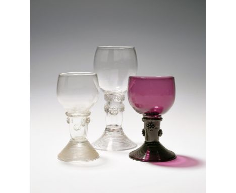 Three English glass roemers for the export market, 18th century, two clear, one amethyst, with cup bowls raised on hollow ste