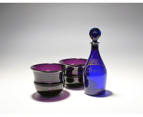 A pair of amethyst glass fingerbowls, early 19th century, with ridged bands around the centre, and a blue glass decanter and 