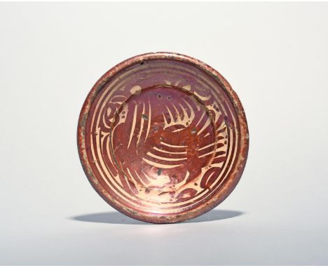 A small Hispano-Moresque lustre dish, 17th/18th century, painted in ruby lustre with a large stylized cockerel within narrow 