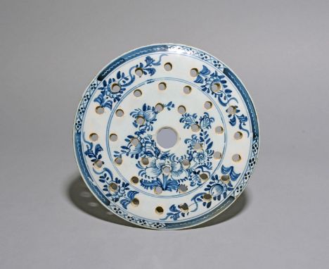 A London delftware strainer or cover, c.1775, the circular form painted in blue with flowering peony branches and pierced wit