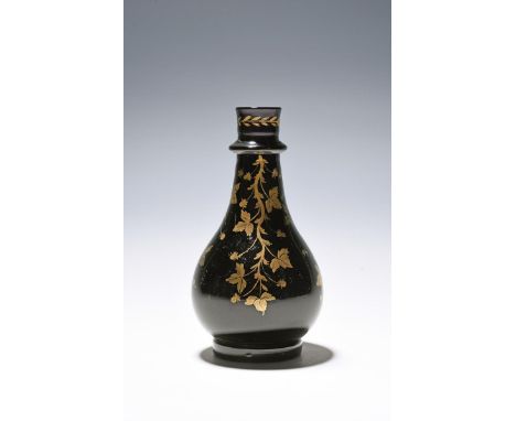 An amethyst glass carafe, late18th/early 19th century, the heavy pear-shaped body decorated in gilt with four vine tendrils b