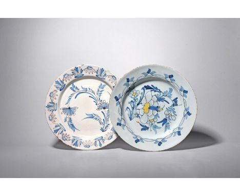 Two delftware chargers, c.1740-60, one painted in blue with polychrome highlights, with a large spray of peony within a forma