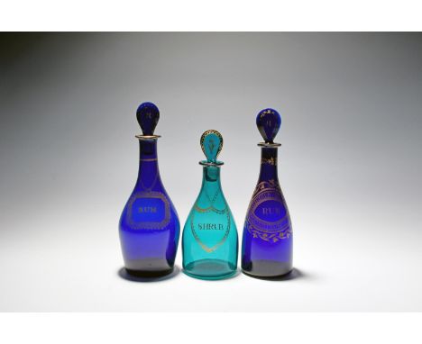 Three small coloured glass decanters and stoppers, c.1790, of differing shape, two of a deep cobalt blue and gilded with bott