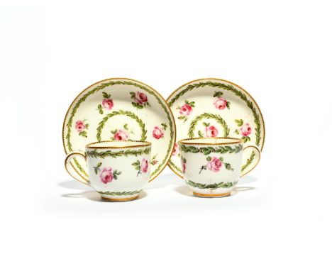 Two Sèvres tea cups and saucers, c.1768-70, painted with scattered pink roses between berried leafy borders, interlaced Ls ma