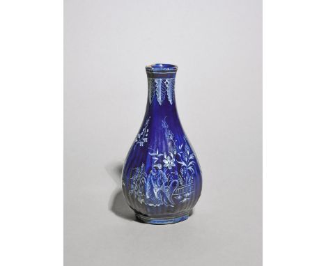 A Continental tin-glazed vase, 18th century, Delft or Nevers, the fluted bottle form decorated in white enamel on a bleu Pers