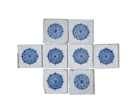 Eight Lambeth delftware tiles, c.1725-60, each painted in blue with a large rosette or stylized rose design, some glaze chipp