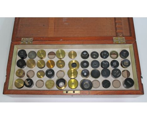 A wooden box of microscope lenses and empty cans apart from one