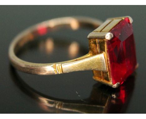 A dress ring set with a rectangular cut synthetic ruby, marked '9ct', gross wt. 2.24g, size L/M.  Condition - general wear in