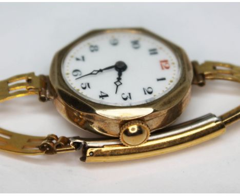 An early 20th century hallmarked 9ct gold wristwatch with white enamel dial having Arabic numerals, gold dot outer minute mar