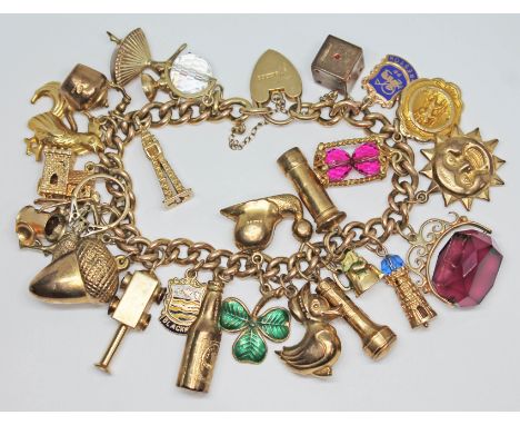 A hallmarked 9ct gold charm bracelet, various charms including Blackpool tower, a church, a bottle of Guinness, postbox, ligh