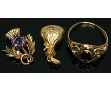 A hallmarked 9ct gold thistle charm set with an amethyst, another charm modelled as a sack and indistinctly marked, together 