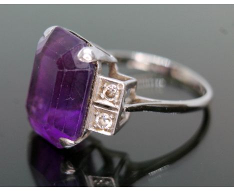 An Art Deco period diamond and amethyst ring, the emerald cut purple amethyst weighing approx. 9.79 carats, diamond set shoul