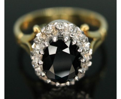 A diamond and sapphire cluster ring, the central dark blue oval cut sapphire weighing approx. 2.00 carats, surrounded by four