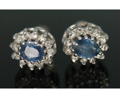 A pair of hallmarked 18ct white gold diamond and sapphire ear studs, each cluster measuring approx. 7mm x 8mm, gross wt. 2.05
