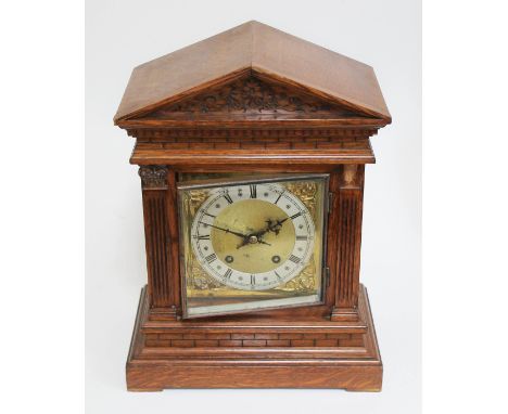 An architectural oak mantle clock, brass and silvered dial, movement striking on two gongs, height 41cm.  