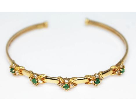 A bangle set with emeralds and colourless stones, 9ct gold import marks, diam. approx. 6cm, gross wt. 8.74g.  Condition - min