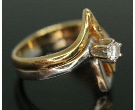 A modern two colour ring set with a modern round brilliant cut diamond weighing approx. 0.10 carats (estimated) above a diamo