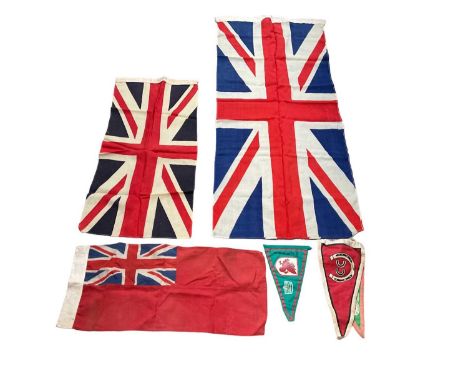 Vintage canvas Union Jack flag on pole, together with other Union Jack flags and pennants.