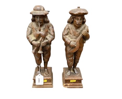 Pair of carved oak figures of musicians, 34cm high