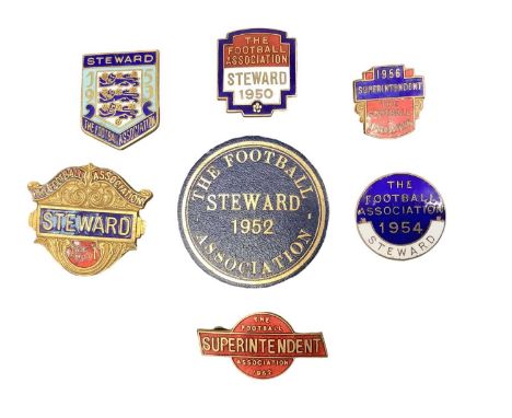 Seven 1950s football badges, each dated between 1950 and 1956, including five enamel steward and superintendent badges and on