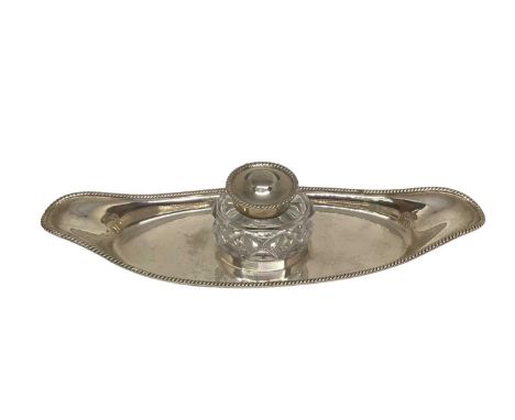 Edwardian silver inkstand with a silver mounted cut glass inkwell on a boat. Shaped silver stand with gadrooned edge, London 