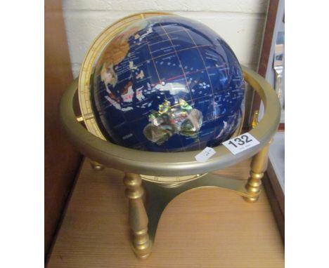 A globe set with different hardstones to each country in brass frame with compass under