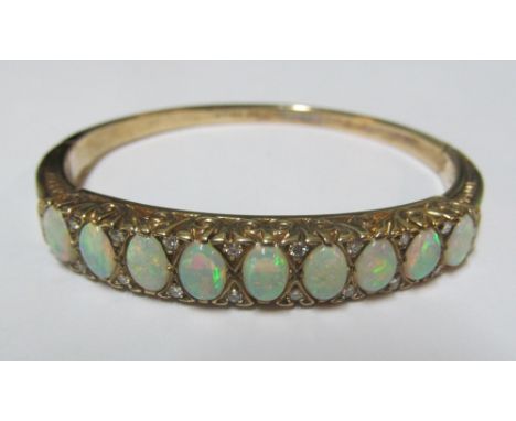 A 9ct gold bangle bracelet set nine opals interspersed with diamonds 56x47mm