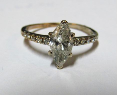 A solitaire lozenge shaped diamond ring with diamond shoulders marked 14kt, size M 108gm, diamond 10x4mm