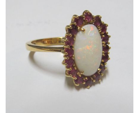 An opal and ruby cluster ring marked 750, size R 8gm