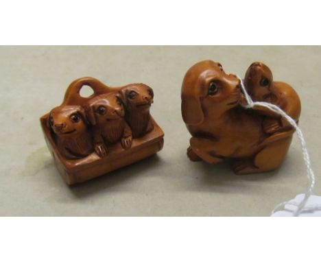 A Netsuke of three dogs in basket and another dog with mouse