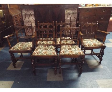 A Set of Six Oak Framed Ercol Dining chairs with Carved Top Rails and Spindle Backs.