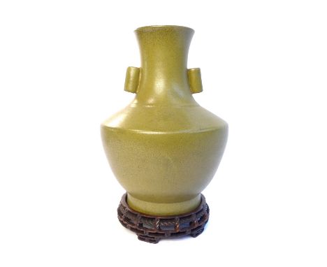 Green glazed Chinese baluster vase, twin cylindrical handles, bears seal mark to base, raised on circular hardwood base. H. 2