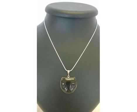 A cat face pendant carved in ox bone with Amethyst cabachon eyes set in a 925 silver surround on a rope chain