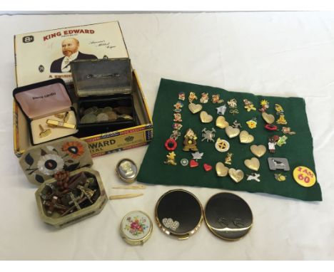 A box of miscellaneous items to include; 2 compacts, boxed Pierre Cardin cufflinks set, pin badges, a metal box of coins and 