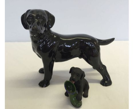 2 black Labrador figurines; 1) ceramic approx 19cm long 2) resin puppy with boot approx 9cm long