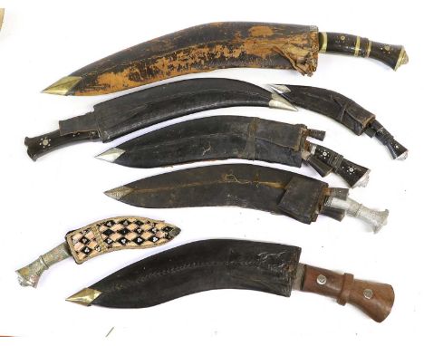 Seven Indian Kukris, of varying sizes, four with horn hilts, one with wood hilt and two with aluminium hilts, each with leath