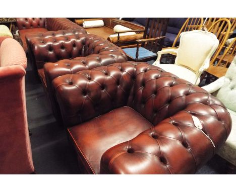 A pair of red leather button back studded Chesterfield chairs
