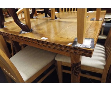 A light oak drawer leaf table raised on floral carved supports