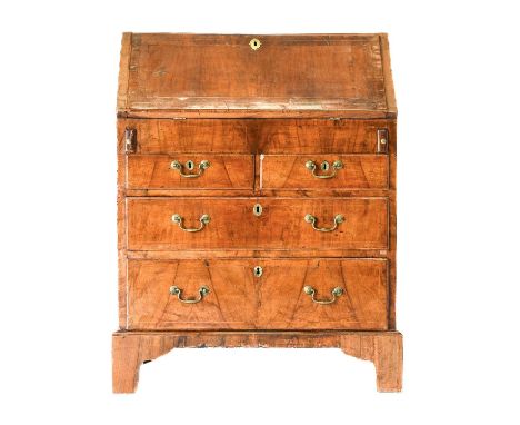 A George I Walnut, Crossbanded and Boxwood-Strung Bureau, early 18th century, the fall front enclosing a fitted interior with