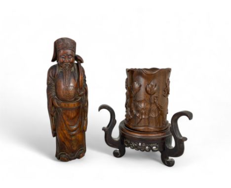 A late 19th century Chinese zitan wood brush pot on stand together with a bamboo carved deity
The cylindrical pot carved with