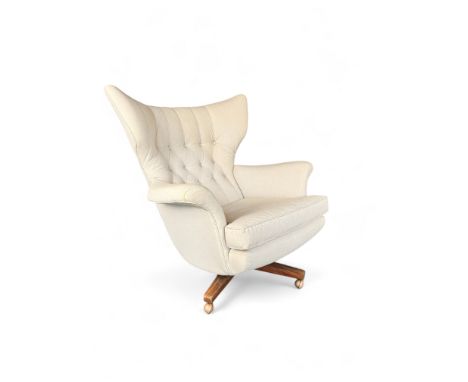 A vintage G-Plan swan back revolving lounge chair

The curved button back, scroll arms and seat reupholstered in cream cotton